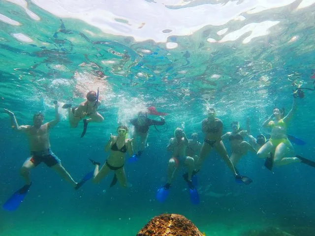 Eine Gruppe von Menschen mit Schnorchelausrüstung posiert unter Wasser.